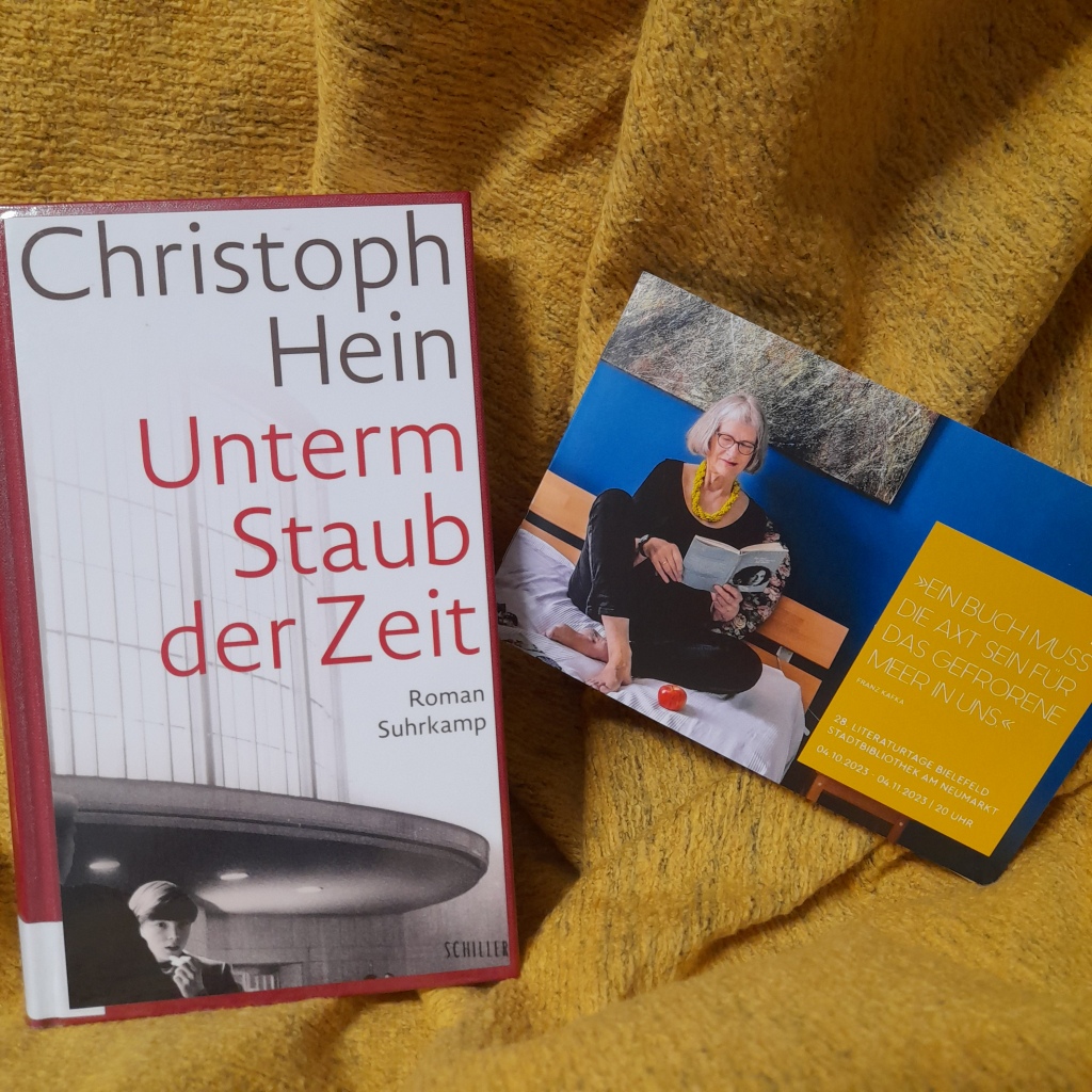 Auf einer gelben Decke liegt der Roman "Unterm Staub der Zeit" von Christoph Hein, Suhrkamp-Verlag. Daneben liegt das Programmheft der Literaturtage 2023.