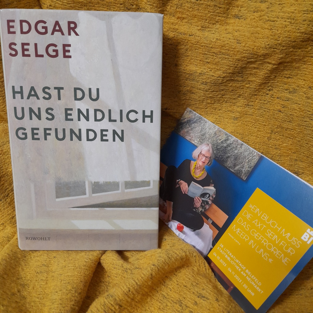 Auf einem gelbem Tuch Liegt das Buch "Hast du uns endlich gefunden" von Edgar Selge, Rowohlt-Verlag; daneben liegt das Programmheft der Literaturtage 2023